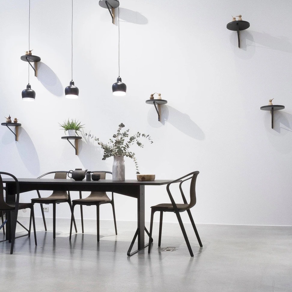 Minimalist dining room with modern pendant lights and wall-mounted shelves